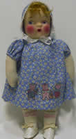 Cloth doll with mask face and 3 pigs applique